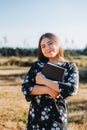 Young smiling religious girl holding a bible under her arm in the field. Sola scriptura. Protestantism Royalty Free Stock Photo