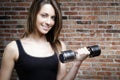 Young smiling woman lifting dumbbells