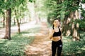 Young smiling sporty woman running in park. Fitness girl jogging in park Royalty Free Stock Photo