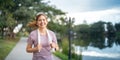 Young smiling sporty woman running in park in the morning. Fitness girl jogging in park Royalty Free Stock Photo