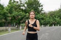 Young smiling sporty woman running in park in the morning. Fitness girl jogging in park Royalty Free Stock Photo