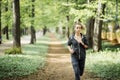 Young smiling sporty woman running in park in the morning. Fitness girl jogging in park Royalty Free Stock Photo