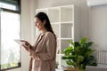 Young smiling successful employee business woman work use hold tablet stand at workplace desk at home office Royalty Free Stock Photo