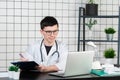 Young and smiling therapist in uniform filling up documents