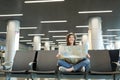 Young smiling traveler tourist woman with crossed legs hold paper map looking aside waiting in lobby hall at Royalty Free Stock Photo