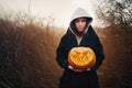 Young smiling woman holding the halloween pumpkin