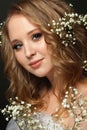 Young smiling woman with blonde curly hair and white flowers on head, beautiful face closeup Royalty Free Stock Photo