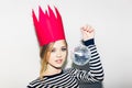 Young smiling woman celebrating party, wearing stripped dress and red paper crown, happy dynamic carnival disco ball Royalty Free Stock Photo