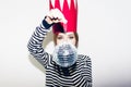 Young smiling woman celebrating party, wearing stripped dress and red paper crown, happy dynamic carnival disco ball Royalty Free Stock Photo