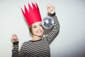 Young smiling woman celebrating party, wearing stripped dress and red paper crown, happy dynamic carnival disco ball Royalty Free Stock Photo