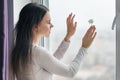 Young smiling woman with chamomile, background window with raindrops, herbal dermatology natural beauty