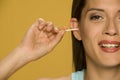 Young smiling woman cleaning her ears with cotton sticks Royalty Free Stock Photo