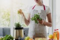 Young smiling woman cooking, making smoothie at home kitchen using blender Royalty Free Stock Photo