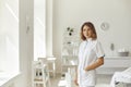 Smiling woman cosmetologist or dermatologist standing and looking at camera in beauty spa salon