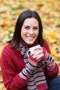 Young smiling woman with cup of tea in autumn park Royalty Free Stock Photo