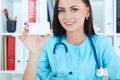 Young smiling woman doctor showing a blank white business card. Royalty Free Stock Photo