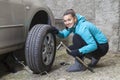 Young smiling woman driver changes car tyres Royalty Free Stock Photo