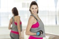 Young smiling woman with dumbbells in the gym. The reflection in the mirror Royalty Free Stock Photo