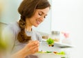 Young woman eating fresh salad in modern kitchen Royalty Free Stock Photo