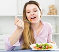 Young smiling woman enjoying tasty green salad Royalty Free Stock Photo