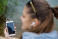 Young smiling woman in excellent spirits with a phone and listens to music Royalty Free Stock Photo