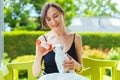 Young smiling woman feeding with milk a white cute kitten from a bottle Royalty Free Stock Photo