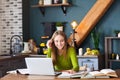 Young smiling woman freelancer sitting at table at home with laptop, making notes Royalty Free Stock Photo