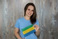 A young smiling woman with a Gabon flag in her hand.