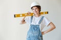 Young smiling woman in hardhat holding yellow level tool Royalty Free Stock Photo