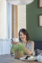 Young smiling woman having breakfast with coffee sitting in cafe. Portrait of girl in pastry shop with cup of tea Royalty Free Stock Photo