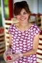 Young smiling woman helding freshly harvested strawberries for sale