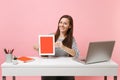 Young smiling woman hold tablet computer with blank empty screen sit work at white desk with contemporary pc laptop Royalty Free Stock Photo