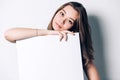 Young smiling woman holding a blank sheet of paper for advertising, Royalty Free Stock Photo