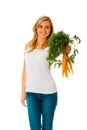 Smiling woman presenting carrots Royalty Free Stock Photo