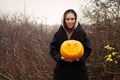 Young smiling woman holding the halloween pumpkin