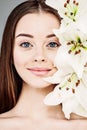 Young smiling woman holding white lily flower, beautiful face closeup Royalty Free Stock Photo