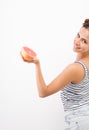 Young smiling woman holds out a grapefruit