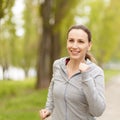 Young smiling woman jogging in park in the morning Royalty Free Stock Photo