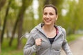 Young smiling woman jogging in park in the morning Royalty Free Stock Photo