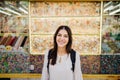 Young smiling woman laughing to camera in front of candy store.Visiting historical place.Traveling on a budget.Backpacker student