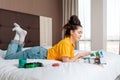 A young smiling woman is lying on the bed and reading a magazine. Reading and recreation. Home interior Royalty Free Stock Photo