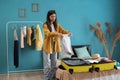 Young smiling woman packing clothes into travel bag. Packing a suitcase and backpack for a trip Royalty Free Stock Photo