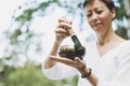 Young smiling woman playing on the brass Tibetan singing bowl outdoor. Sound therapy and meditation Royalty Free Stock Photo