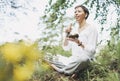 Young smiling woman playing on brass Tibetan singing bowl outdoor. Sound therapy and meditation Royalty Free Stock Photo