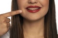 A young smiling woman pointing on her dentures