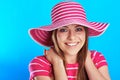 Young smiling woman posing in with hat against blue background Royalty Free Stock Photo