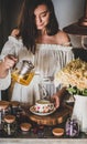 Young smiling woman pouring tea from pot into porcelain cup Royalty Free Stock Photo