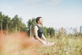 Young smiling woman practice yoga outdoors in city. New normal social distance. Physical and mental health Royalty Free Stock Photo