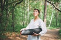 Young smiling woman practice yoga outdoors in the forest. Physical and mental health Royalty Free Stock Photo