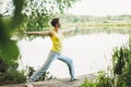 Young smiling woman with beads practice yoga outdoors. New normal social distance. Physical and mental health Royalty Free Stock Photo